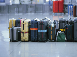 空港内に置かれたスーツケースの写真