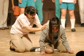 うずくまる女の子の肩に手をやる女性の役者の写真 うずくまる女の子の肩に手をやる女性の役者の写真