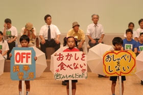 携帯OFF、おかしを食べない、おしゃべりをしないのプラカードをもつ子どもたちの写真 携帯OFF、おかしを食べない、おしゃべりをしないのプラカードをもつ子どもたちの写真