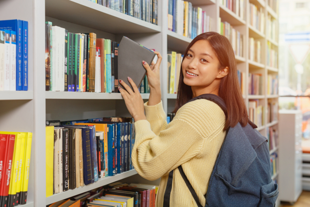 図書館で本を選ぶ女性