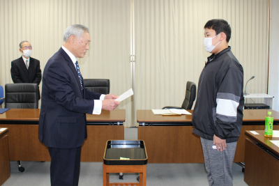 青少年を育てる小美玉市民の会から代表児童へ議員証書を渡している写真