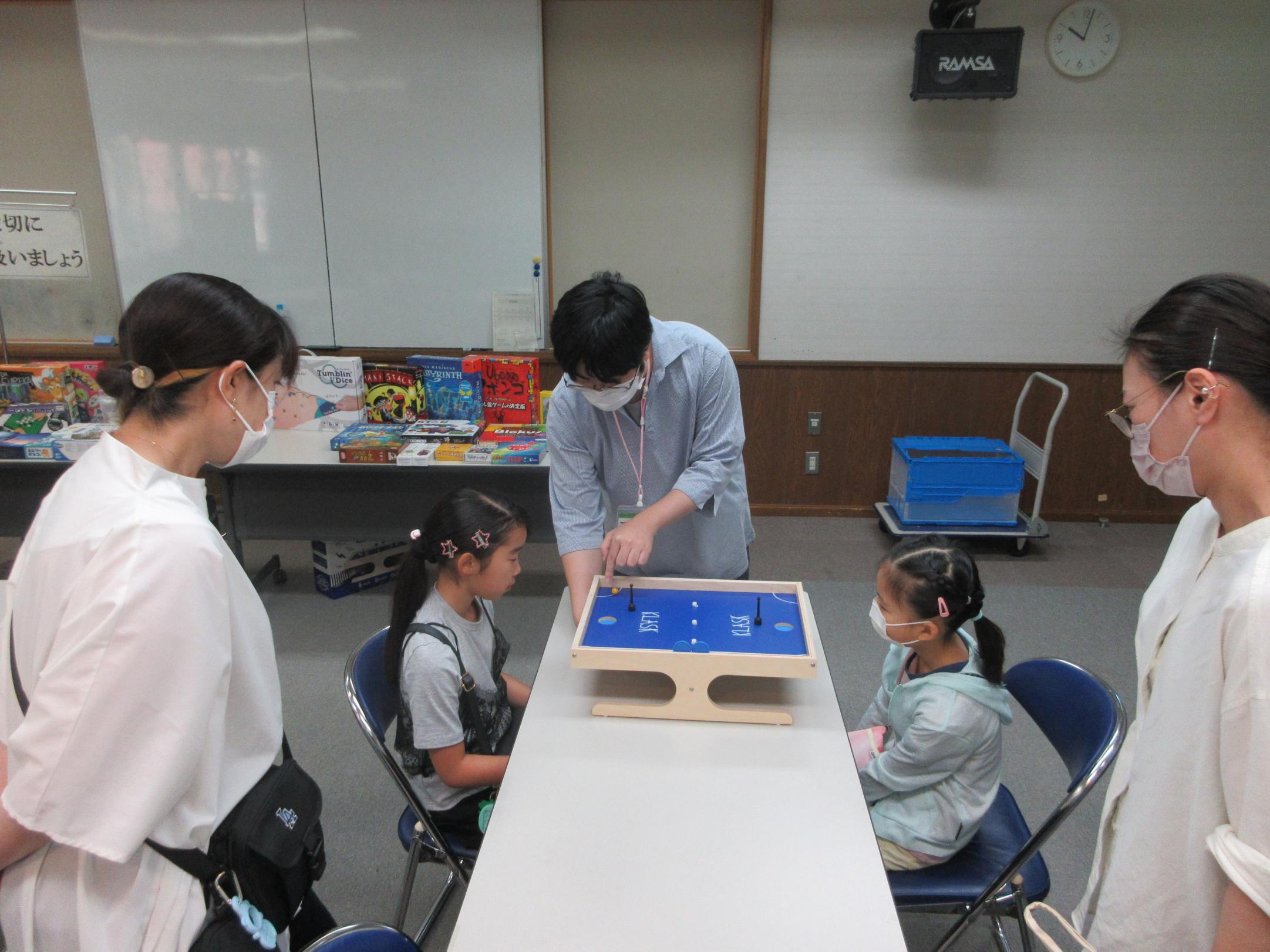 ボードゲームを教えている様子