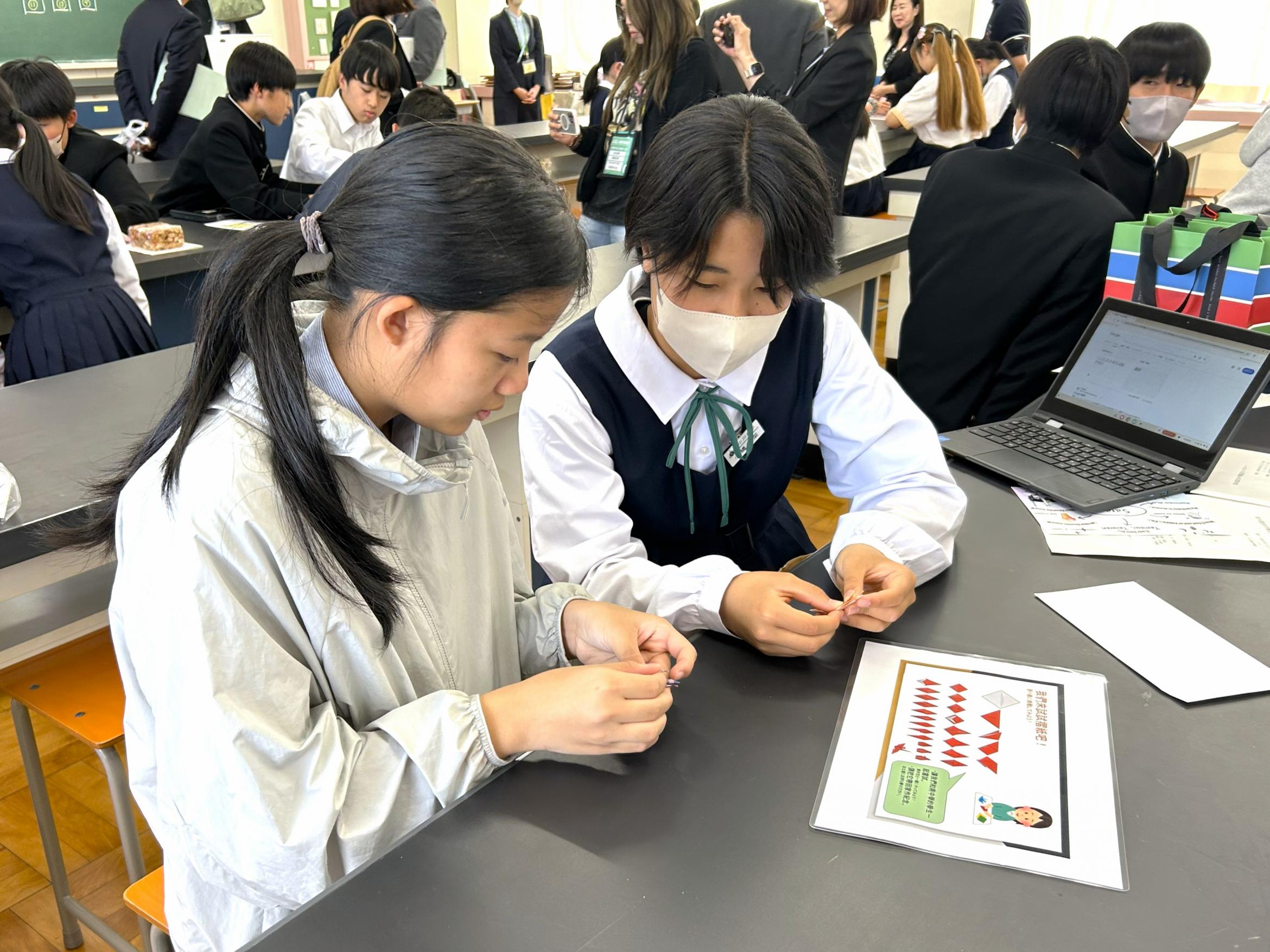 淡水国民中学生徒(左)がバディと一緒に折り紙体験