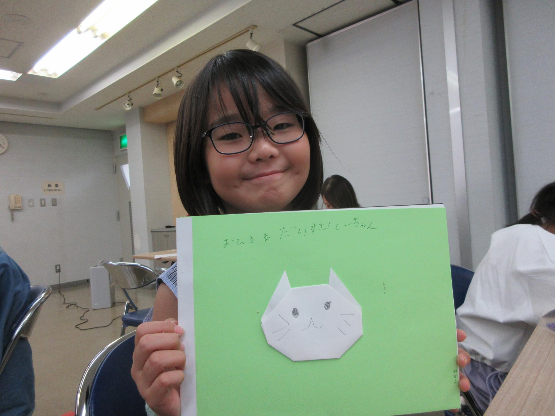 白いねこの絵本を見せてくれる参加者 白いねこの絵本を見せてくれる参加者